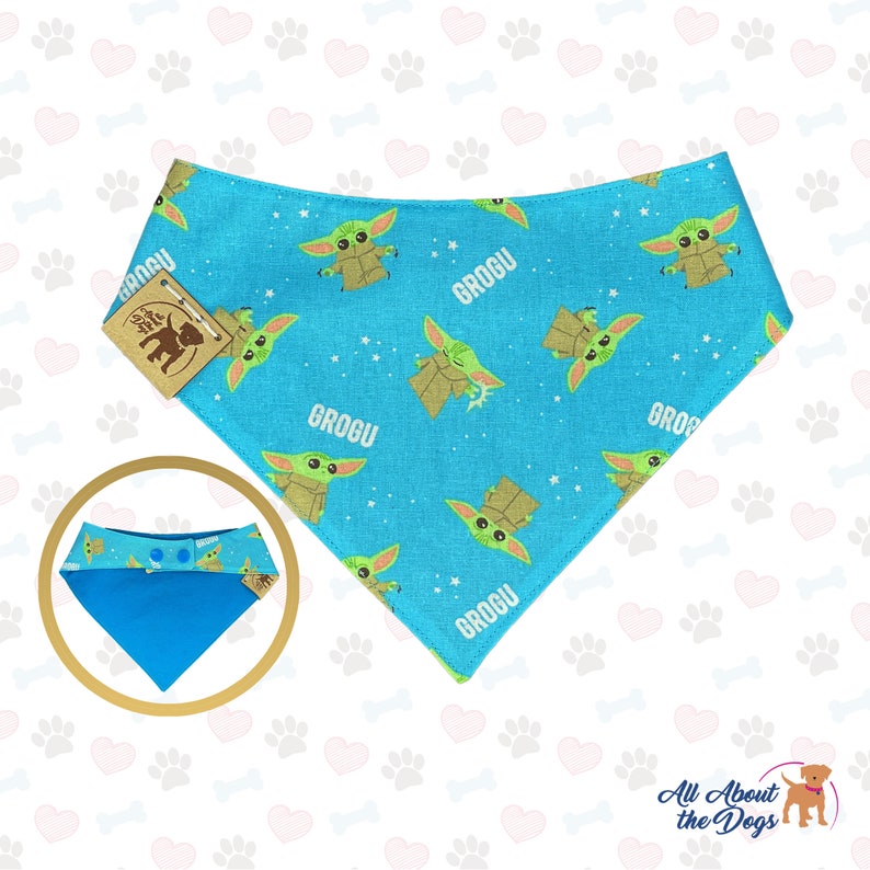 May include: A blue bandana with a pattern of green baby Yoda characters and the word "Grogu" repeated. The bandana has a snap closure and is reversible.