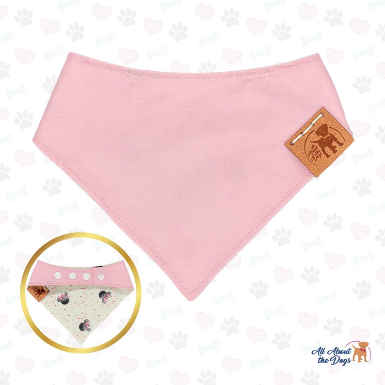 May include: A light pink dog bandana with a triangular shape. The bandana has a stitched edge and a small brown leather tag with a dog silhouette. A smaller bandana with a Minnie Mouse pattern is shown in a gold circle.