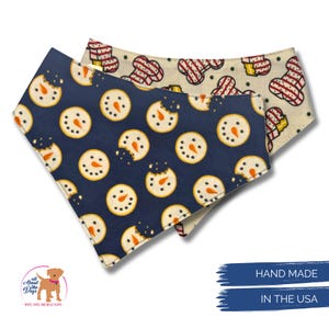 May include: Two dog bandanas with festive patterns. One is navy blue with snowman cookie designs, and the other is off-white with gingerbread man designs. The bandanas are handmade in the USA.