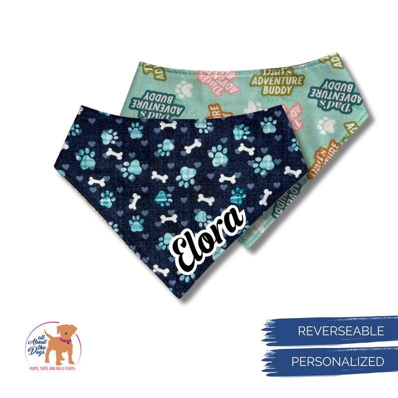 Puede incluir: Dos pa&ntilde;uelos reversibles para perros. Uno es azul marino con huellas de patas y huesos turquesa, y el nombre "Elora". El otro es verde claro con el texto "Dad's Adventure Buddy". Los pa&ntilde;uelos son personalizados.
