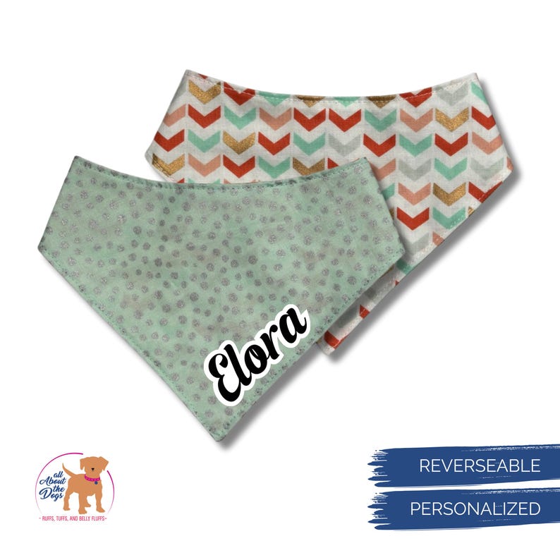 May include: Two reversible dog bandanas. One is mint green with silver dots and the name "Elora" in white. The other has a chevron pattern in gold, red, and mint green. The bandanas are personalized.