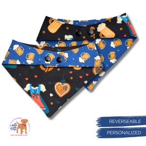 K&ouml;nnte beinhalten: Wende-Hunde-Bandana mit einem schwarzen und blauen Bierkrugmuster. Die R&uuml;ckseite zeigt einen schwarzen Hintergrund mit einem Lebkuchenherz und einem traditionellen Kleidungsdesign. Das Bandana ist personalisierbar und hat schwarze Druckkn&ouml;pfe.