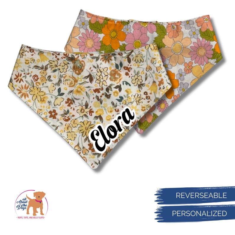 Pode incluir: Tr&ecirc;s bandanas revers&iacute;veis e personalizadas para c&atilde;es com estampas florais. Uma bandana &eacute; branca com flores amarelas e marrons, outra tem flores laranja, rosa e amarelas, e a terceira tem flores laranja e rosa. O nome "Elora" &eacute; impresso em uma bandana.