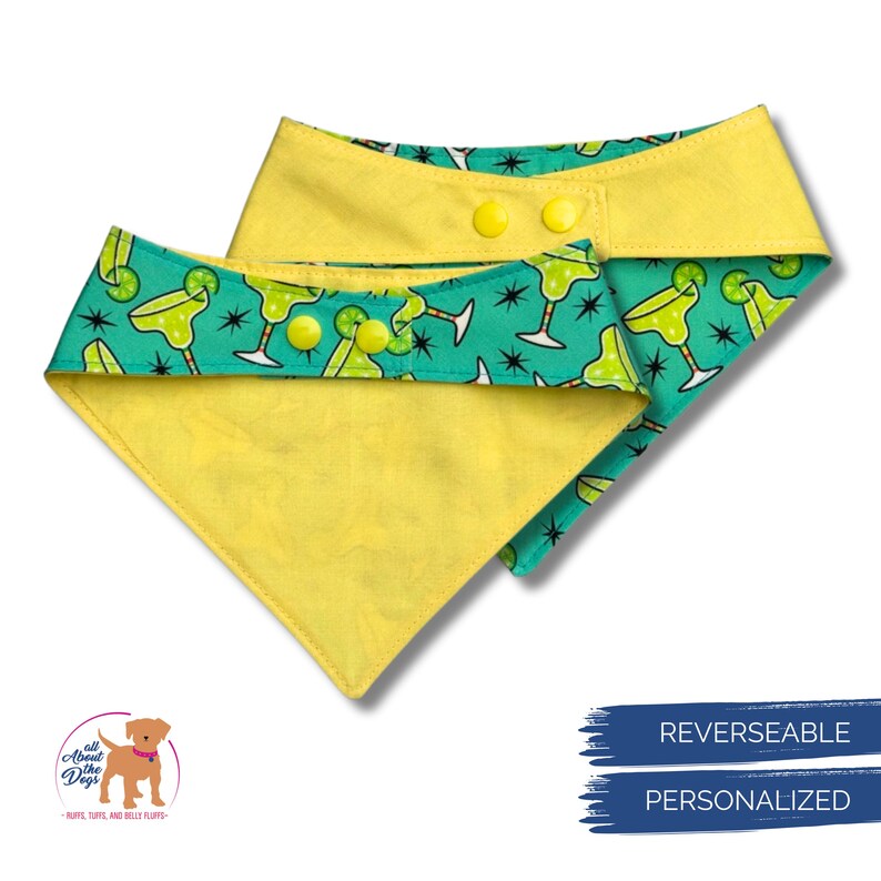May include: Reversible dog bandana with a yellow and turquoise margarita design. The bandana features a yellow backing and a turquoise front with margarita glasses and starbursts. It has yellow snap closures.