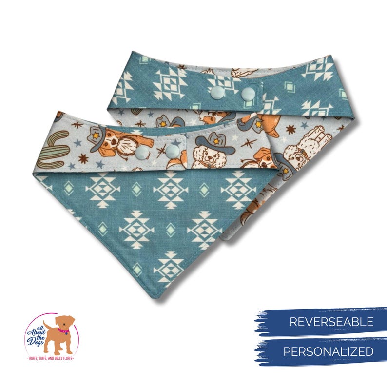 May include: Two reversible dog bandanas. One side has a teal geometric pattern, the other a light grey pattern with cowboy dogs, cacti, and stars. Each bandana has two light blue press studs for closure.