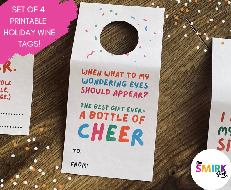 May include: Set of four printable holiday wine tags. One tag reads "When what to my wondering eyes should appear? The best gift ever - a bottle of CHEER." Includes space to write "To" and "From". The Smirk Shop logo is in the bottom right.