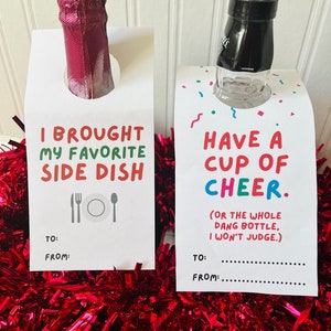 May include: Two white gift tags with text and bottles. One says "I BROUGHT MY FAVORITE SIDE DISH" with a fork, plate, and spoon. The other says "HAVE A CUP OF CHEER" with confetti. Both have "TO:" and "FROM:" lines.