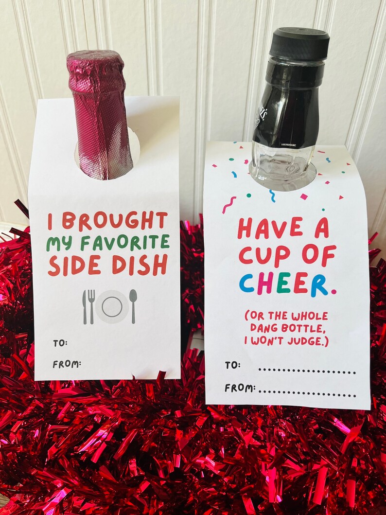 May include: Two white gift tags with text and bottles. One says "I BROUGHT MY FAVORITE SIDE DISH" with a fork, plate, and spoon. The other says "HAVE A CUP OF CHEER" with confetti. Both have "TO:" and "FROM:" lines.