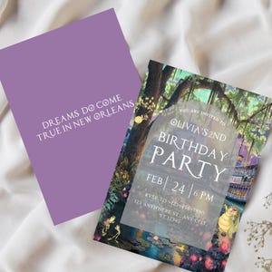 May include: A purple invitation card with white text that reads "Dreams do come true in New Orleans". The invitation is for Olivia's 2nd birthday party. The background of the invitation is a watercolor illustration of a swamp scene with a boat, frogs, and lily pads.