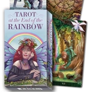 May include: A Tarot at the End of the Rainbow deck box featuring a fairy with red hair and purple wings, alongside three tarot cards depicting a wolf in a snowy forest, a fairy with a stone wheel, and a person falling near a rainbow and gold.