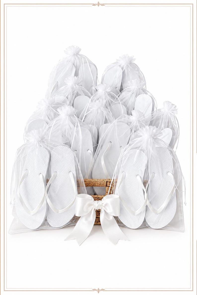 May include: A collection of white flip-flops, each individually packaged in a sheer white organza drawstring bag. The bags are arranged in a woven wicker basket, which is decorated with a large, smooth white satin ribbon bow at the front.