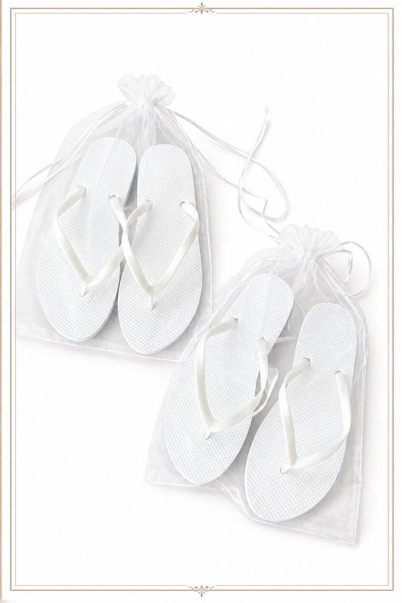 May include: Two pairs of solid white flip-flops, each pair individually packaged in a sheer white organza drawstring bag. The flip-flops feature a textured footbed and smooth, thin straps, presented in a clean, minimalist arrangement.