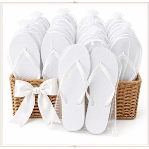 May include: A collection of white flip-flops, each individually wrapped in clear plastic bags, arranged inside a rectangular woven wicker basket. A large, white satin ribbon bow is attached to the front of the basket, which holds multiple pairs of footwear.