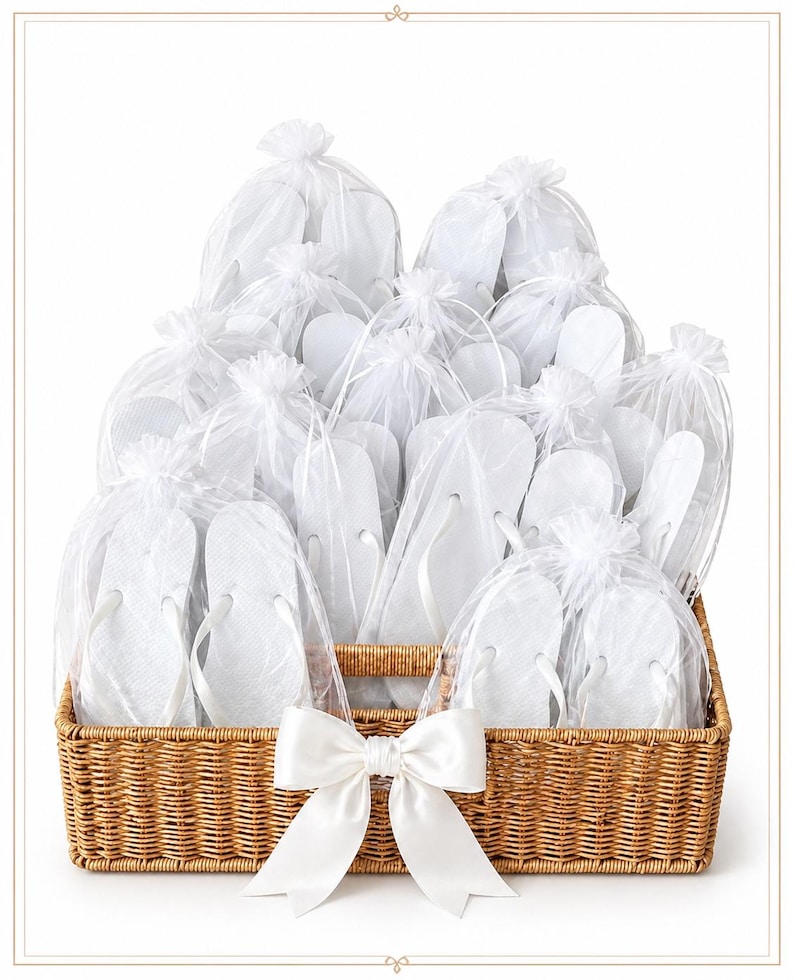 May include: A rectangular woven wicker basket filled with multiple pairs of white flip-flops, each individually packaged in a sheer white organza drawstring bag. A large white satin ribbon bow is attached to the front centre of the basket.