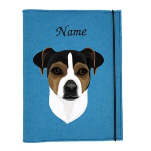 Könnte beinhalten: Eine blaue Filz-Notizbuchhülle mit einer Illustration eines Jack Russell Terriers. Der Hund hat braune, schwarze und weiße Markierungen. Das Wort "Name" ist in schwarzer Schrift oben geschrieben. Ein schwarzes Gummiband sichert die Hülle.