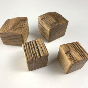 Könnte beinhalten: Vier kleine Holzblöcke mit rustikalem, verwittertem Finish. Die Blöcke sind alle unterschiedlich groß und geformt und haben eine natürliche Holzfarbe.