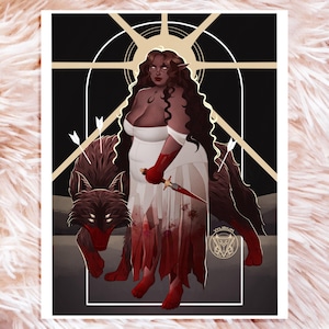 Puede incluir: Una impresión artística que representa a una mujer con un vestido blanco, sosteniendo una daga ensangrentada, con un lobo. La obra de arte tiene un tema oscuro y gótico, con un fondo negro y detalles dorados. La mujer tiene pelo largo y oscuro y orejas puntiagudas.