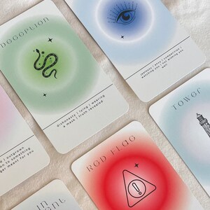 May include: A set of tarot cards with colorful backgrounds and illustrations. The cards feature the words "Deception", "Red Flag", "Tower", and "Intuition".