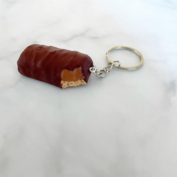 Porte-clés en forme de doigt de biscuit au chocolat et au caramel (morsure)