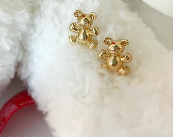 May include: A pair of gold-tone teddy bear stud earrings. The bears are sitting upright with their paws outstretched.