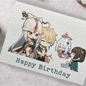 May include: A greeting card with a cartoon illustration of four anime characters. The characters are smiling and holding gifts. The card has the text "Happy Birthday" printed on it.
