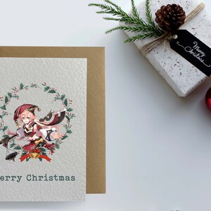 May include: A Christmas card featuring an anime character in a red and white outfit with a wreath of holly and berries around her. The card has the text "Merry Christmas" at the bottom.