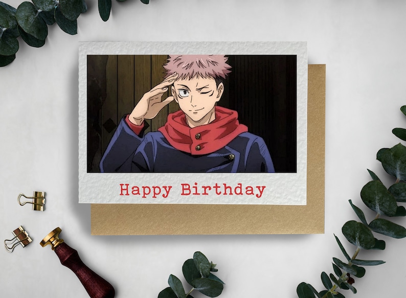 May include: A birthday card featuring an anime character with pink hair, wearing a blue jacket and red scarf, with the text "Happy Birthday" in red.