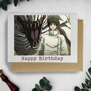 May include: A birthday card featuring a man in a white coat standing in front of a large, toothy, white creature. The card has the text "Happy Birthday" printed on the front.