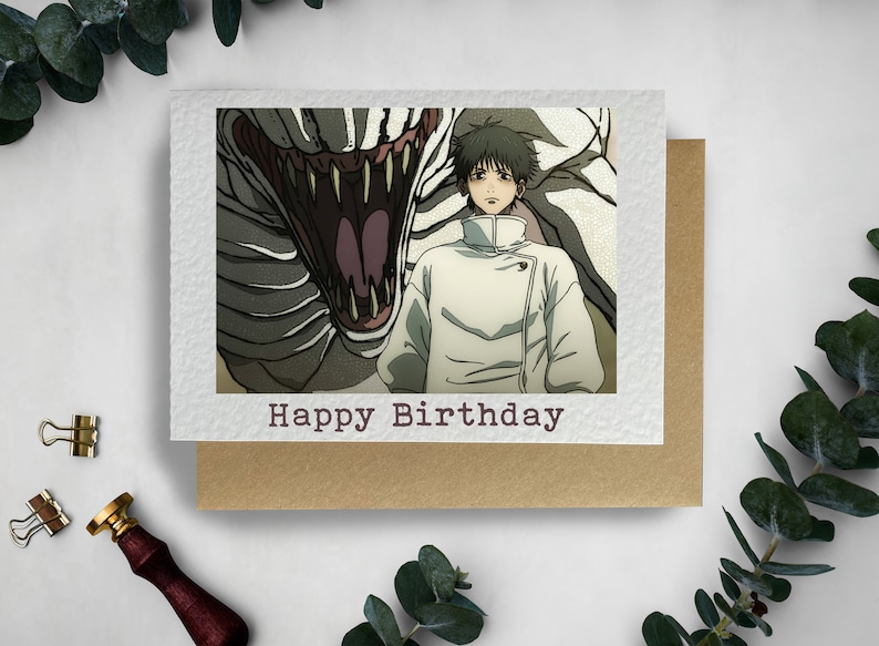 May include: A birthday card featuring a man in a white coat standing in front of a large, toothy, white creature. The card has the text "Happy Birthday" printed on the front.