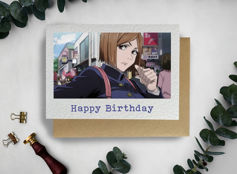 May include: A birthday card with a photo of an anime character with brown hair and a blue uniform. The text "Happy Birthday" is printed on the card.