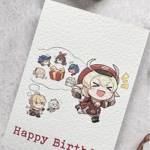 May include: A birthday card with a cartoon illustration of a character with blonde hair and red horns. The character is wearing a red and white outfit and is holding a gift box. The card has the text "Happy Birthday" in red.