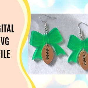 May include: A pair of earrings featuring green bow shapes and brown football pendants. The earrings have silver-colored hooks. The image also includes the text "DIGITAL SVG FILE" in black letters.