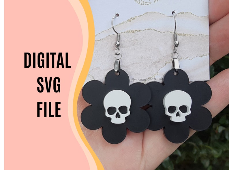 Puede incluir: Pendientes negros con forma de flor y una calavera blanca en el centro. Los pendientes tienen ganchos plateados. Tambi&eacute;n se muestra el texto "DIGITAL SVG FILE". Fabricados con material mate.
