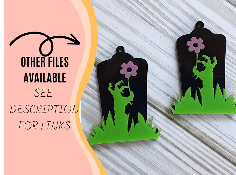 Puede incluir: Dos decoraciones de Halloween con forma de l&aacute;pida negra con una mano de zombi sosteniendo una flor rosa. Las l&aacute;pidas tienen hierba verde en la base. El texto "OTHER FILES AVAILABLE SEE DESCRIPTION FOR LINKS" est&aacute; a la izquierda.