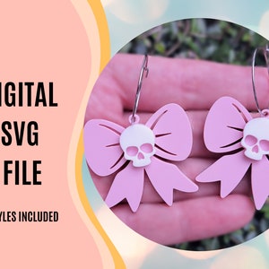 May include: Two pink bow earrings with a white skull cutout in the center. The earrings are on a silver hoop. The text "DIGITAL SVG FILE" and "2 STYLES INCLUDED" is on the left side of the image.