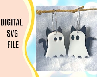 Peut inclure: Boucles d'oreilles fantômes chat blanches et noires suspendues à une branche dorée. Les boucles d'oreilles ont la forme d'un fantôme avec des oreilles de chat et une queue. Le texte "DIGITAL SVG FILE" est visible.