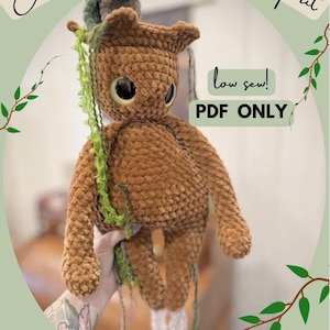 May include: A brown crocheted forest spirit doll with large black eyes, green accents, and a small headpiece. The doll has a textured, plush appearance and is labeled "low sew! PDF ONLY". The image also includes the text "Elowyn the Ethereal Forest Spirit".