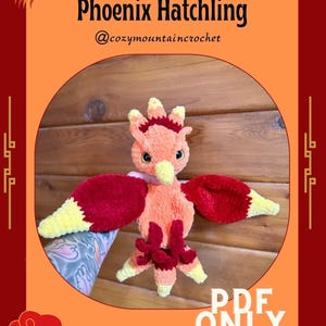 Peut inclure: Un bébé phénix crocheté aux tons orange, rouge et jaune. L'oiseau a des ailes déployées et un design détaillé. Le texte sur l'image indique "Solaris Phoenix Hatchling" et "PDF ONLY".