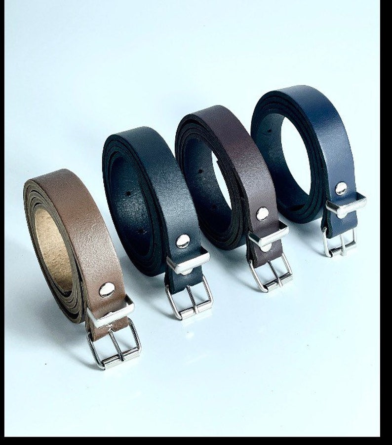 May include: Four leather belts with silver buckles in brown, black, dark brown, and navy blue.