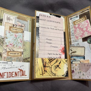 May include: A handmade, tri-fold journal with a vintage aesthetic. The journal features various paper ephemera, including specimen labels, a document, and floral patterned paper. The cover includes the word "CONFIDENTIAL" in red. The journal is tied with a black string and weighs 198 grams.