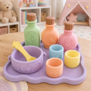 May include: A silicone toy set featuring a light purple cloud-shaped tray, a matching purple bowl with a yellow spoon, three bottles with brown caps in light green, orange, and pink, and three small cups in blue, yellow, and orange.