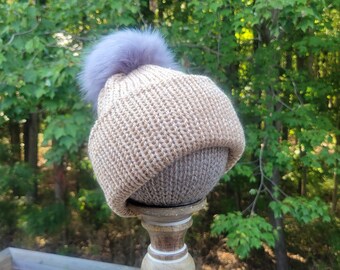 Handgemaakte gebreide beige volwassenenmuts met klavermotief en grijze pompon.