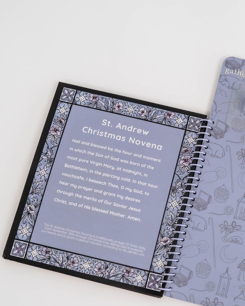 May include: A spiral-bound notebook with a light purple cover and pages. The open page displays text: "St. Andrew Christmas Novena." The border features a floral design in shades of purple and white. The adjacent page has a repeating pattern of line drawings.