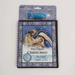May include: A spiral-bound activity book titled "The First Christmas" with a blue and white border. The cover features an illustration of Mary, Joseph, and baby Jesus. Includes a blue water pen and four reusable boards. The packaging reads "gather & pray" and "Ages 3+".