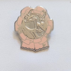 May include: A silver-colored pin with a pink border. The pin features a stylized image of a dragon holding a cup. The border is a light pink color with a scalloped edge. A small Mickey Mouse head is at the bottom.