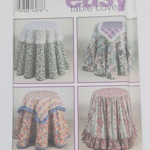 May include: A Simplicity pattern for easy table covers. The package features four different table cover designs with floral and patterned fabrics. The text "design your own easy table covers" is visible.
