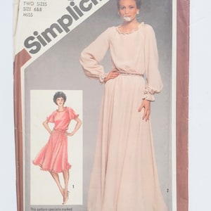 May include: A Simplicity sewing pattern envelope 7824 for sizes 6 and 8. The cover features a long-sleeved, floor-length dress with a ruffled neckline and cuffs, and a shorter version with ruffled sleeves. Text includes Simplicity 7824 and Miss.