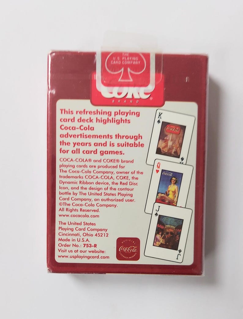 K&ouml;nnte beinhalten: Ein versiegeltes Kartenspiel von Coca-Cola in einer roten Schachtel. Die Schachtel zeigt das Coca-Cola-Logo und Text, der Vintage-Werbung hervorhebt. Die Karten zeigen klassische Coca-Cola-Bilder. Hergestellt von The United States Playing Card Company.