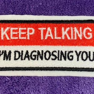 Puede incluir: Parche bordado blanco y rojo con texto negro que dice "KEEP TALKING I'M DIAGNOSING YOU".