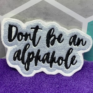 May include: White embroidered patch with a gray background and black text that reads "Don't be an alphahole".